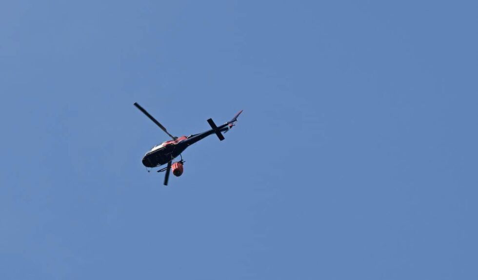 HELIKOPTER: Brannhelikopter er på stedet og holder på med slukking. FOTO: OLAV SVALAND