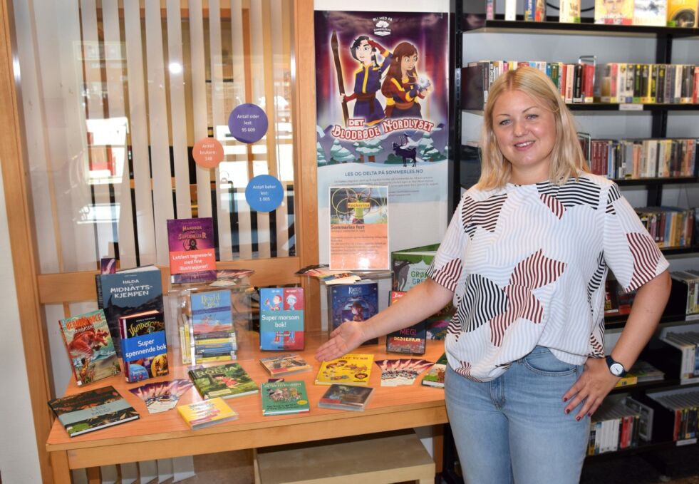 POPULÆRE: Kristina Solsvik viser frem noen av de mange barnebøkene som blir lånt ut under lesekampanjen. De mest populære bøkene er tegneserier og Amuletten-serien, forteller hun.