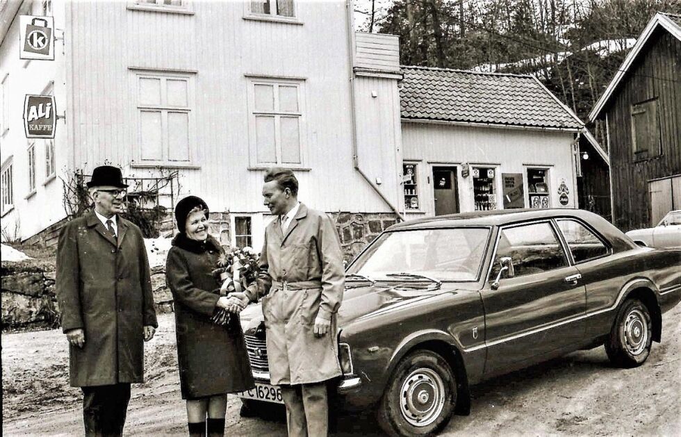 LEVERING: Petra og Rangbert Rustenberg vant i 1972 en fin Ford Taunus på K-kjøpmennenes gratislotteri. Kjøpmann Kjell Oland gledet seg stort over å kunne overlevere den flotte gevinsten. Den gamle butikken på Kamperhaug var en fin ramme rundt begivenheten. Og Rangbert dro hjem og pugget trafikkregler for å ta førerkort. FOTO: SALVE HAUGAAS