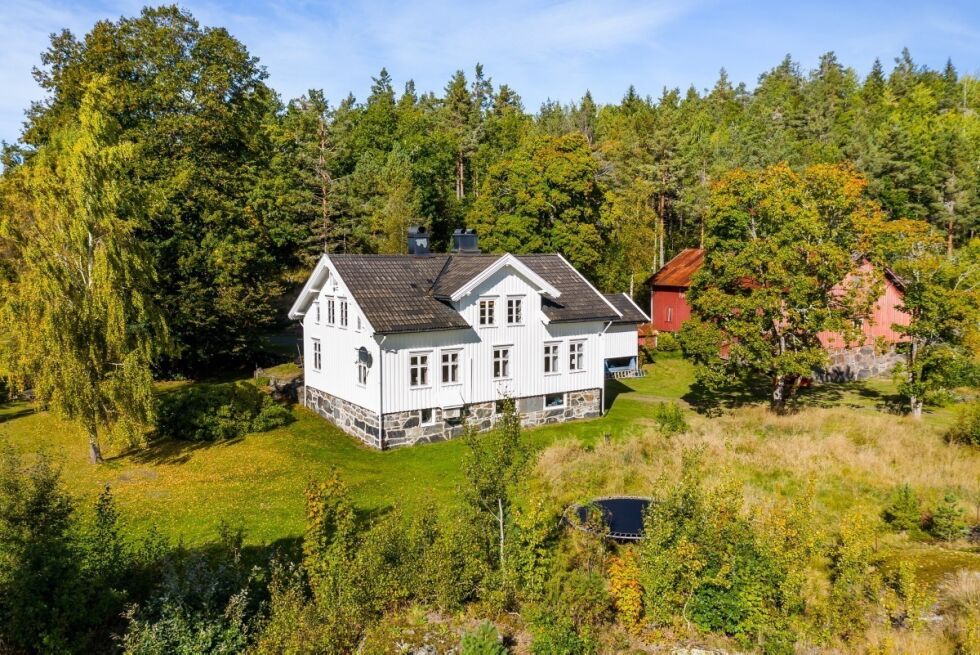 GÅRDEN: Eiendomsmeglerens dronefoto av eiendommens hovedbygninger, der våningshus, låve og stabbur kan ses.